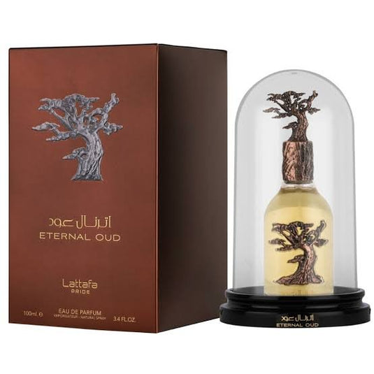 A box of Lattafa **Lattafa Eternal Oud 100ml Eau De Parfum** and a clear dome encasing the bottle. The packaging features a tree design, highlighting the amber fragrance. It is labeled as 100ml, EAU DE PARFUM.