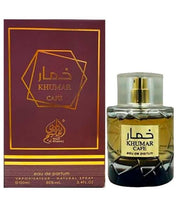 A clear 100ml bottle of Khumar Cafe Wadi Al Khaleej EDP (Spicy Coffee) by Lattafa, with a gold cap and amber unisex scent, stands beside its matching maroon and gold box packaging.