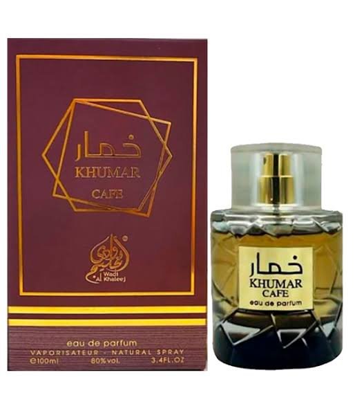 A clear 100ml bottle of Khumar Cafe Wadi Al Khaleej EDP (Spicy Coffee) by Lattafa, with a gold cap and amber unisex scent, stands beside its matching maroon and gold box packaging.