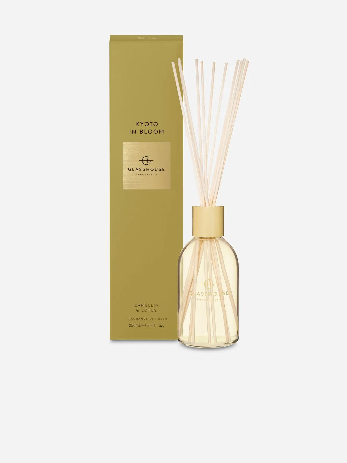 A stunning Rio Perfumes Kyoto in Bloom Glasshouse 250ml Diffuser with wooden reeds stands beside its green box.