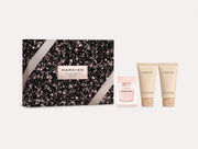 Narciso Rodriguez Cristal Eau de Parfum Gift Set by Narciso Rodriguez, featuring a black and pink sparkling box, an Eau de Parfum Cristal bottle, and two beige skincare tubes displayed on a white background.