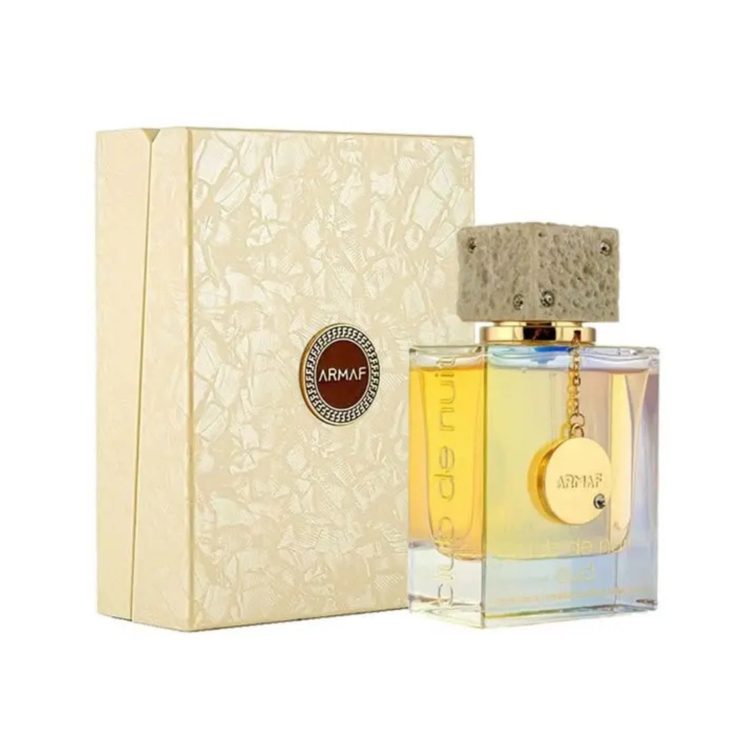 Armaf Club de Nuit Oud 105ml Eau De Parfum for men, with its textured cap and gold charm beside a beige box, encapsulates the refined allure of Cambodian Oud.