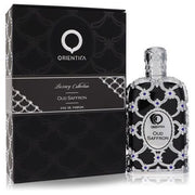 A bottle of Orientica Luxury Collection Oud Saffron by Rio Perfumes, a premium unisex fragrance, is shown beside its elegant black and silver box.