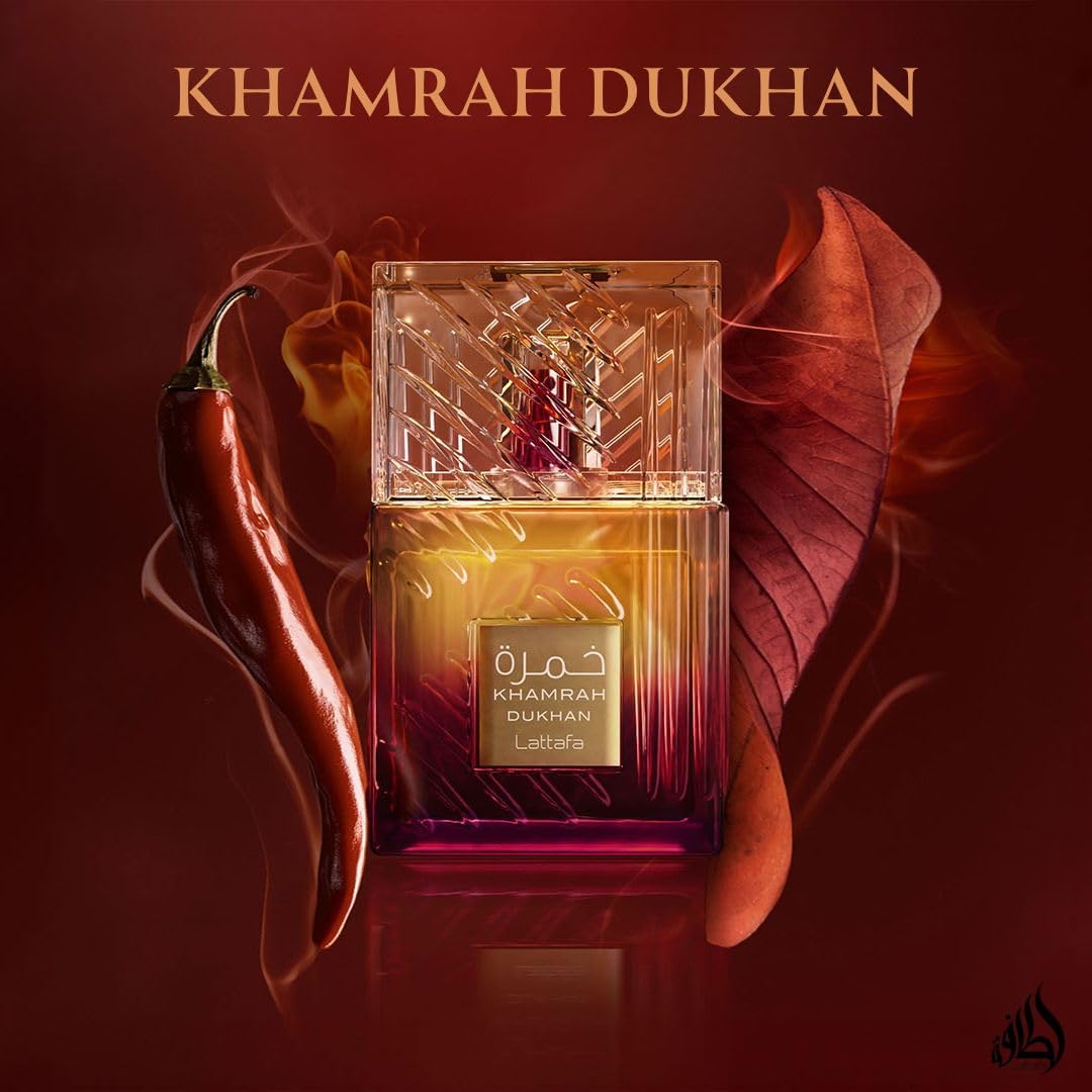 A bottle of Lattafa Khamrah Dukhan 100ml Eau De Parfum by Lattafa is shown with a red chili pepper and brown leaf on a smoky red background, emphasizing the bold character of this unisex fragrance.