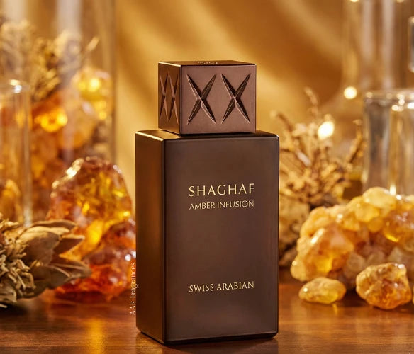 The Swiss Arabian Shaghaf Amber Infusion 75ml EDP bottle sits on a surface, surrounded by amber stones and dried botanicals, capturing the luxurious essence of this signature amber fragrance by Swiss Arabian.