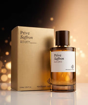 Fragrance World Privé Saffron 60ml EDP, a luxurious oriental spicy scent, stands beside its gold box packaging against a softly blurred golden backdrop.