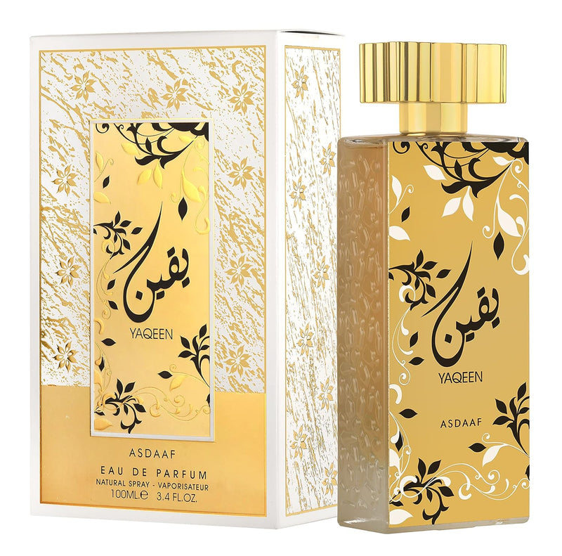 Load image into Gallery viewer, Golden and white Asdaaf Yaqeen 100ml Eau De Parfum perfume bottle with intricate patterns and Arabic calligraphy, packaged in a matching box by Dubai Perfumes.
