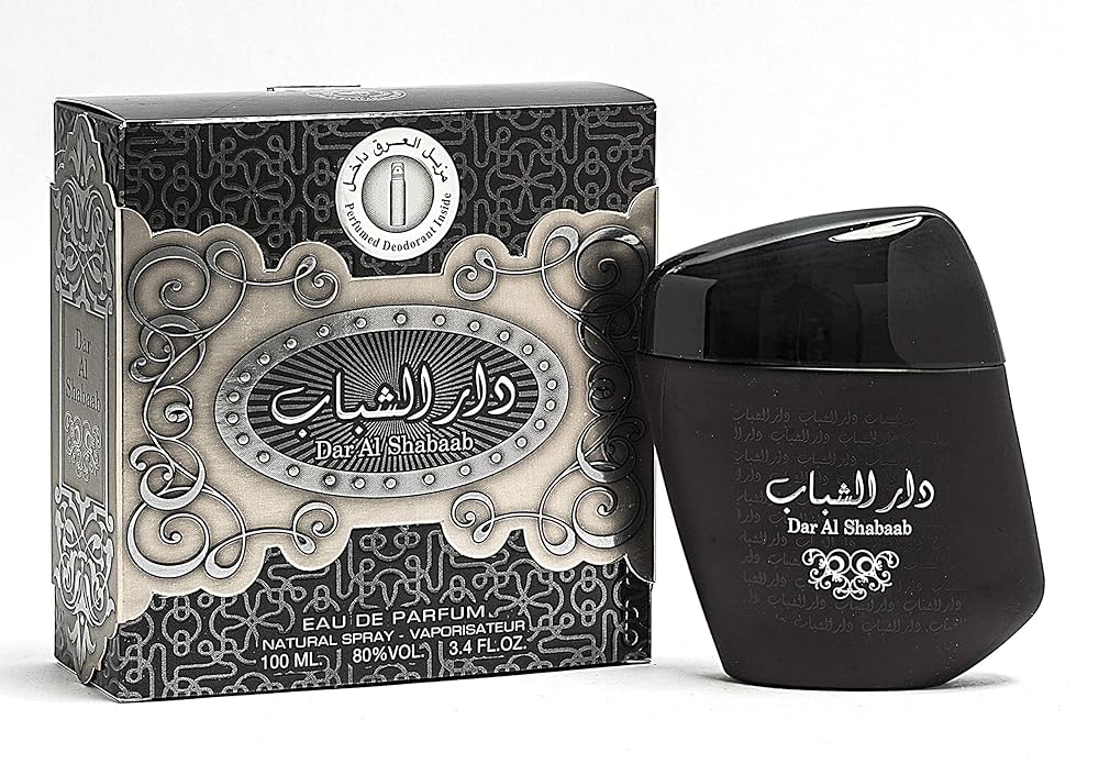 A black bottle of Ard Al Zaafaran Dar Al Shabab 100ml Eau de Parfum stands beside its elegant black and silver box, both featuring Arabic and English text. This unisex fragrance is from the Ard Al Zaafaran brand.