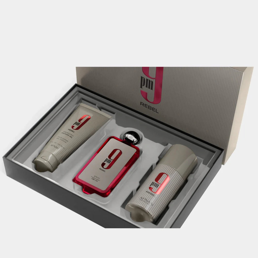 The Afnan 9PM Rebel 100ml EDP Gift Set by Afnan features three items—a tube, a stick, and a bottle of Afnan 9PM Rebel Eau De Parfum with a round cap—all labeled “9 PM Rebel” and elegantly arranged in a branded box with a white inner tray. This unisex fragrance collection leaves an unforgettable impression.