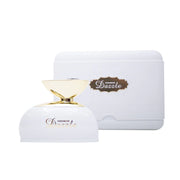A white and gold bottle of Al Haramain Dazzle 100ml EDP by Rio Perfumes sits in front of its matching white case, featuring a gold and brown label.