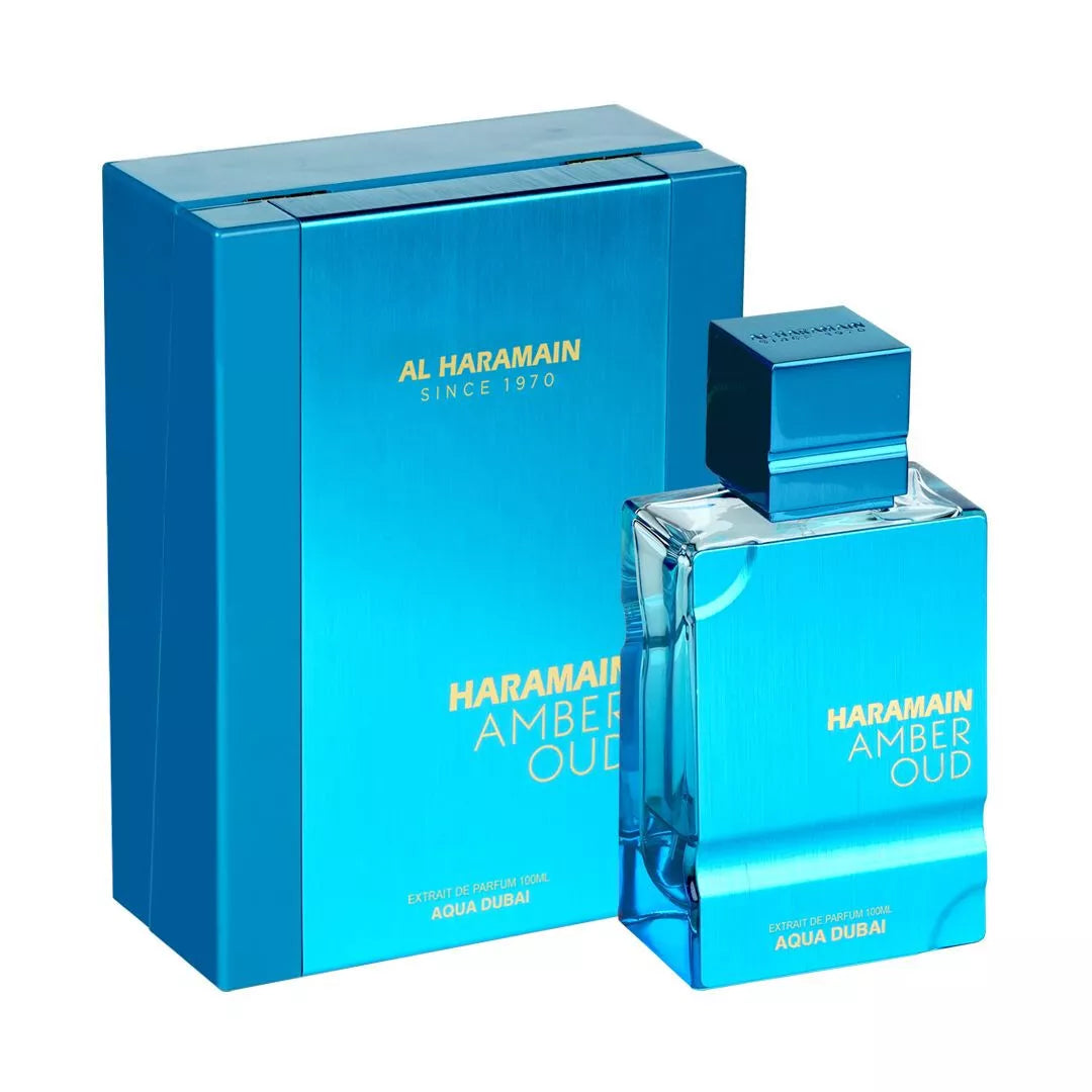 A blue box and matching bottle labeled "Al Haramain Amber Oud Aqua Dubai 100ml Extrait De Parfum," a refreshing unisex fragrance, are displayed side by side.