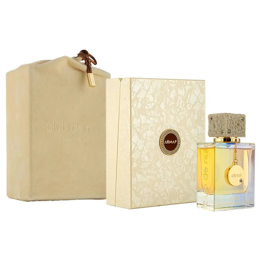 A 105ml bottle of Armaf Club de Nuit Oud Eau De Parfum, with a textured cap, is showcased beside a beige box and pouch. This refined men's fragrance embodies the essence of Cambodian Oud.