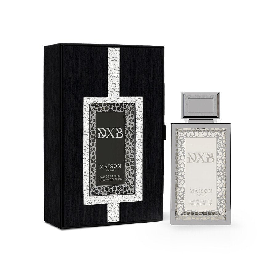 A rectangular bottle of Maison Asrar DXB 100ml EDP, presented alongside its coordinating black and silver box adorned with a decorative geometric pattern, embodies the refined essence of Maison Asrar with its Citrus Aromatic fragrance—a sophisticated unisex Eau de Parfum crafted for any occasion.