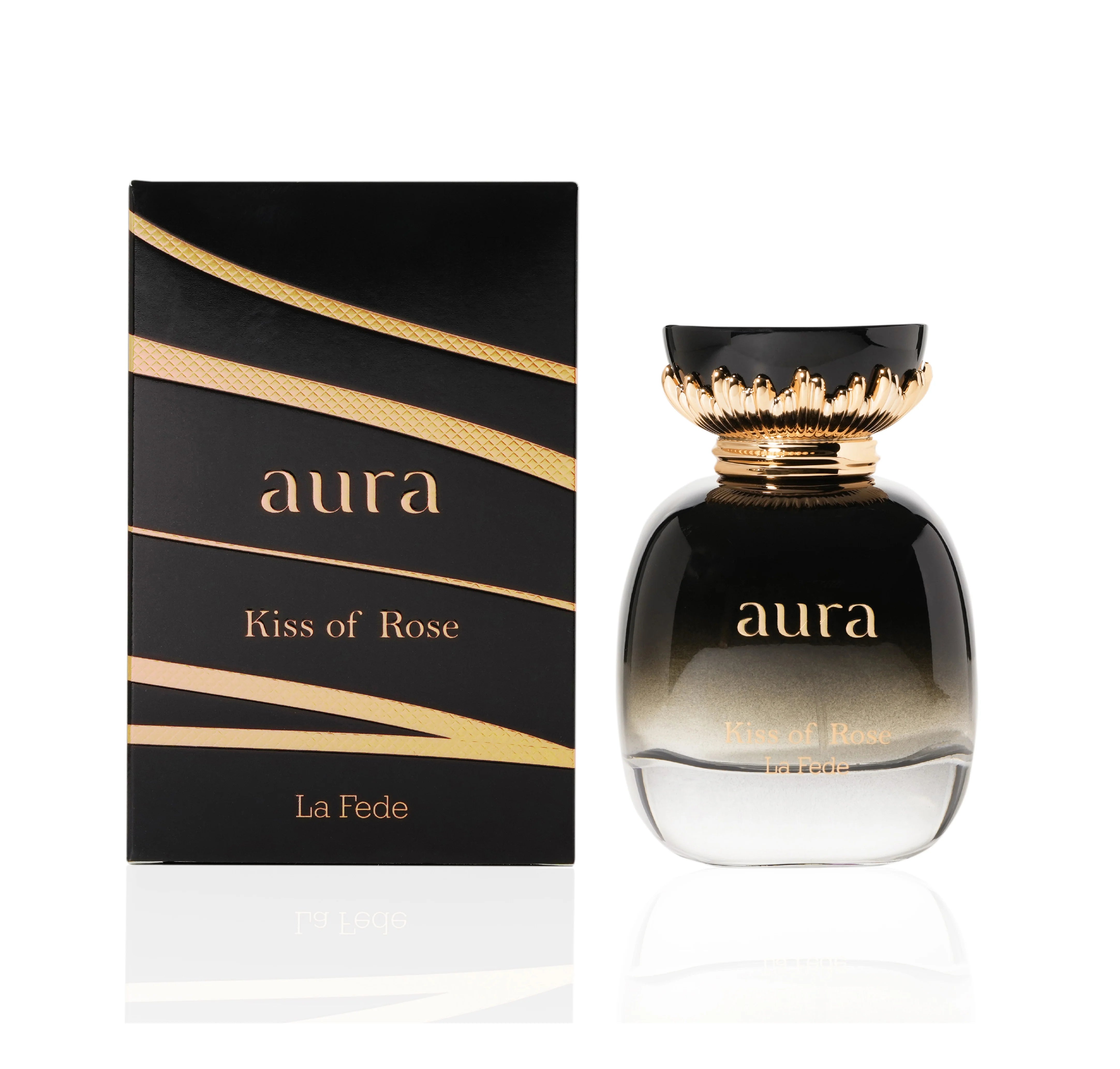 A perfume bottle labeled "Khadlaj La Fede Aura Kiss of Rose 100ml Eau De Parfum" is showcased next to its matching black and gold packaging. The clear bottle with a black top adorned in gold detailing embodies the essence of Eau de Parfum, delivering a captivating fragrance for men & women.