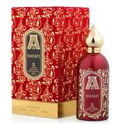 The Attar Collection Hayati 100ml EDP is a unisex fragrance in a red and gold bottle with ornate patterns and a pointed gold cap, presented in matching packaging from the Attar Collection brand.