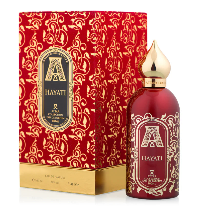 The Attar Collection Hayati 100ml EDP is a unisex fragrance in a red and gold bottle with ornate patterns and a pointed gold cap, presented in matching packaging from the Attar Collection brand.