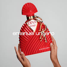A person holds a sculpted red bottle of Emanuel Ungaro Diva Rouge 100ml EDP for women against a plain background.