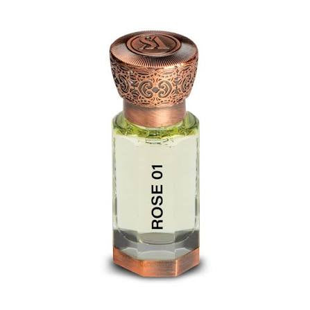 A clear glass bottle labeled “Swiss Arabian Rose 01 Concentrated Oil” with a decorative copper-colored cap and filled with pale yellow liquid beautifully captures the delicate, floral essence of Swiss Arabian’s rose fragrance.