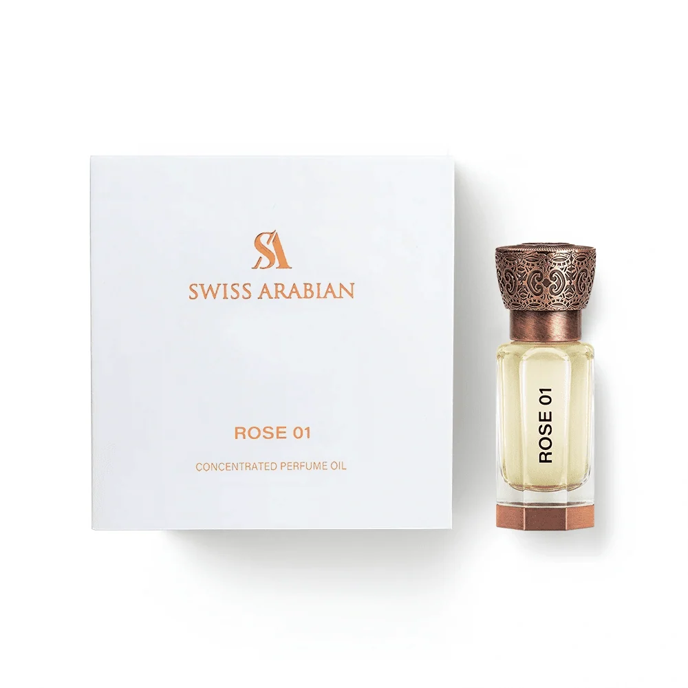 A square box labeled “Swiss Arabian Rose 01 Concentrated Oil” stands beside a clear glass bottle with an ornate cap, both carrying the “Rose 01” name. Created by Swiss Arabian, this concentrated oil surrounds you in a rich, elegant rose perfume for a truly luxurious floral experience.