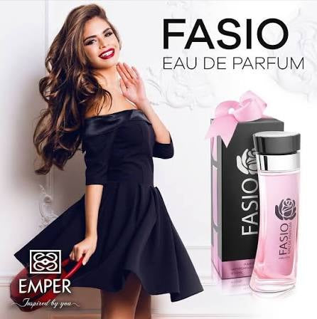 A woman in a black dress poses beside a bottle and box of Rio Perfumes Emper Fasio 100ml EDP, featuring a pink ribbon on the packaging—a captivating fragrance for women.