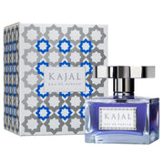 A bottle of Kajal Eau de Parfum by Kajal is displayed in front of its packaging, which features gray and blue geometric patterns.