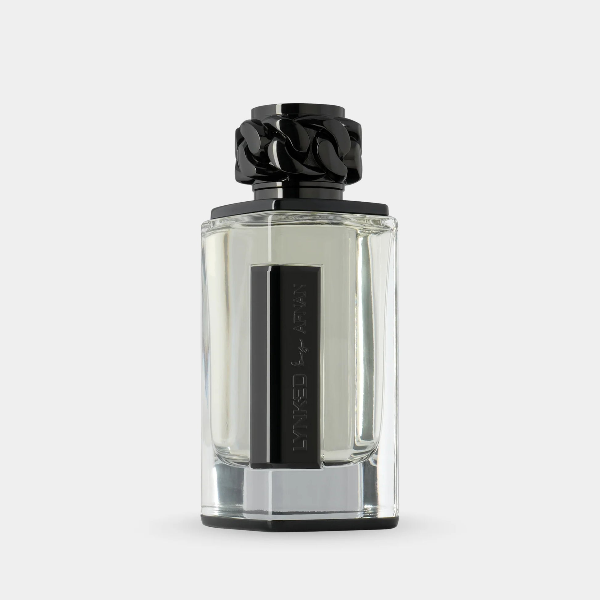 Afnan Lynked Freedom 100ml EDP by Afnan is shown in a clear glass bottle with a black rectangular label and decorative cap, set against a light gray background, reflecting its aromatic spicy scent.