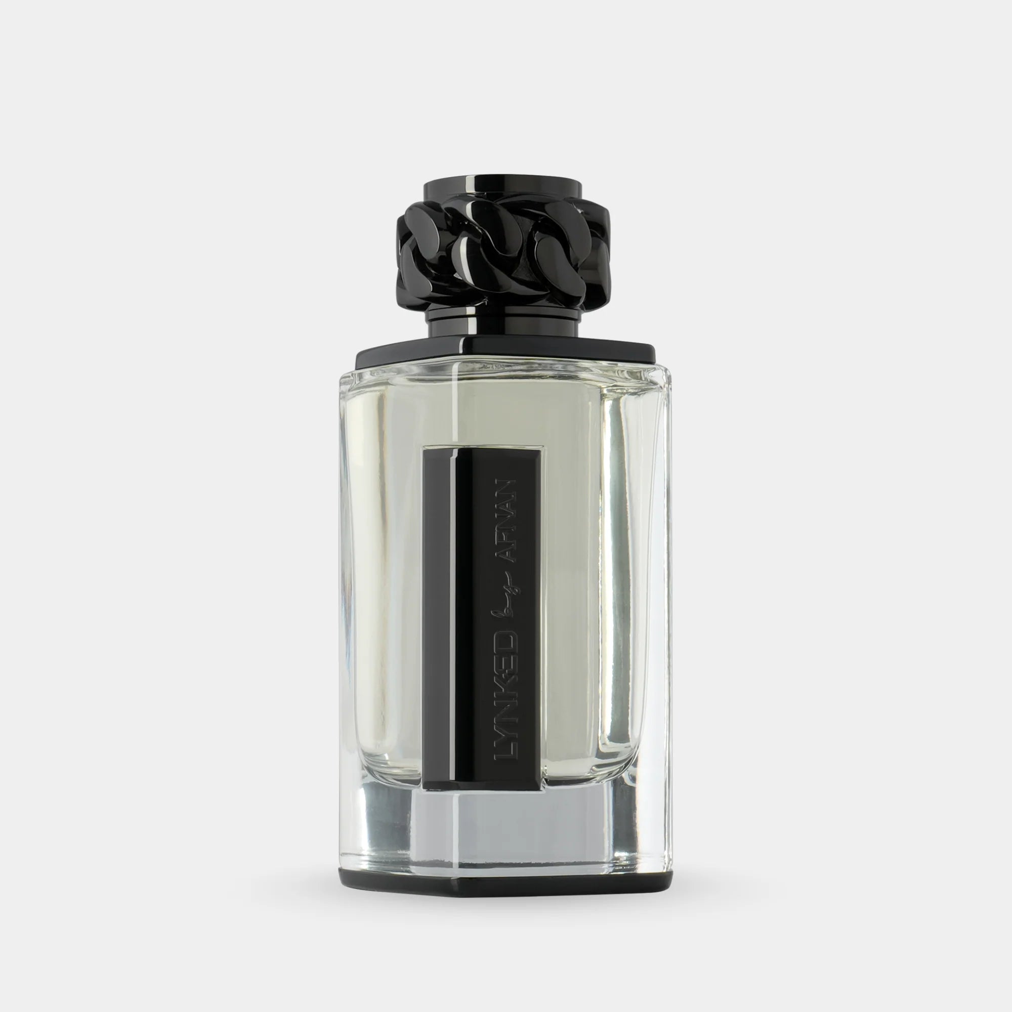 Afnan Lynked Freedom 100ml EDP by Afnan is shown in a clear glass bottle with a black rectangular label and decorative cap, set against a light gray background, reflecting its aromatic spicy scent.