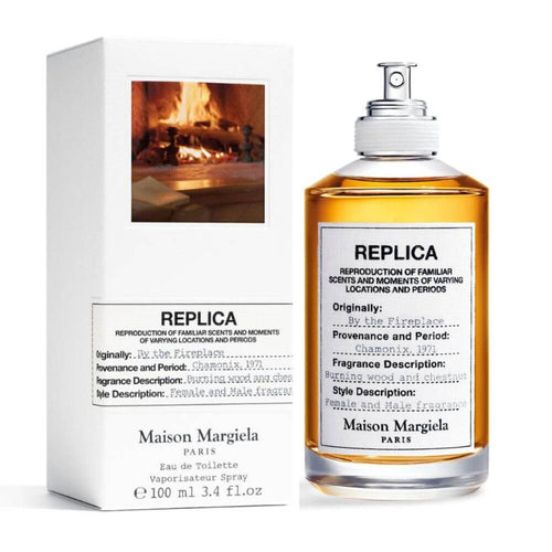 A Maison Margiela REPLICA By The Fireplace 100ml Eau De Parfum bottle displayed in front of a box.