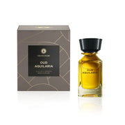 A bottle of golden Oman Luxury Oud Aquilaria 100ml EDP with a black cap stands next to its square, grey gift box with gold line accents.