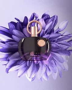 Afnan Supremacy Purple 90ml EDP by Afnan, featuring a dark purple bottle with a gold cap, rests on a vivid purple flower against a soft purple background, highlighting the elegance of this women's Eau De Parfum.
