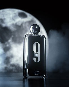Afnan 9 PM 9PM 100ml EDP by Afnan is displayed standing upright before a luminous full moon with mist swirling in the background.