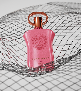 Afnan Supremacy Gala 90ml Eau De Parfum by Afnan, in a pink bottle with a gold cap, sits on a metallic mesh surface for an elegant women's fragrance display.