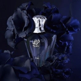 Afnan Turathi Homme Blue 90ml Eau De Parfum by Afnan features a deep blue bottle with a silver cap, displaying Arabic script, set amid dark blue petals against a dark backdrop—an elegant fragrance for men.