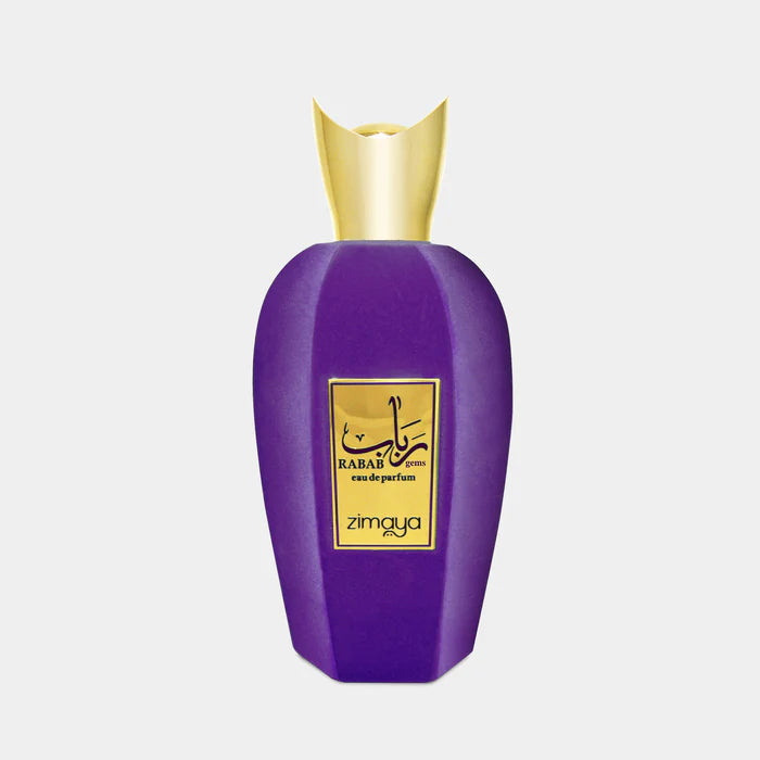 A purple Rue Broca perfume bottle with a gold cap and label reading "Zimaya Rabab Gems Eau de Parfum" rests on a light background—an elegant, sophisticated unisex fragrance.