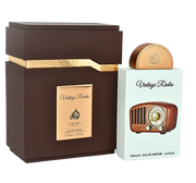A brown and gold box stands beside a Lattafa Pride Vintage Radio 100ml Eau De Parfum bottle, labeled "Vintage Radio" by Lattafa and adorned with a retro radio design—an elegant unisex fragrance for any collection.