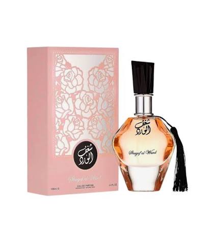 A perfume bottle adorned with a black tassel sits beside its pink floral-patterned box labeled “Al Wataniah Shagaf Al Ward.” This enchanting Eau de Parfum by Al Wataniah delivers a captivating Oriental Floral fragrance in a generous 100ml size.