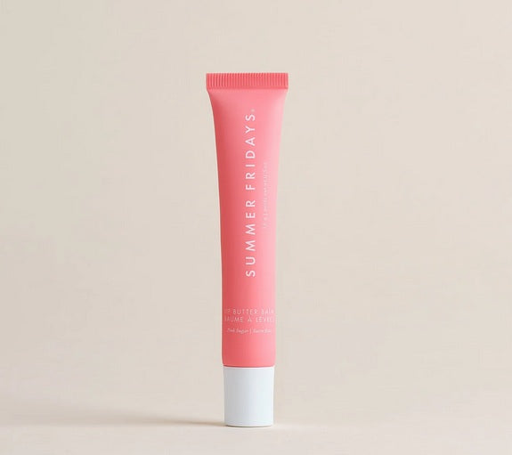 A tube of Summer Fridays Lip Butter Balm Pink Sugar by Summer Friday, in a pink shade with a white cap, stands upright against a beige background.