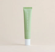 A green tube of Summer Fridays Lip Butter Balm Sweet Mint by Summer Friday, a vegan lip balm, stands upright against a plain beige background.