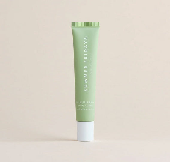 A green tube of Summer Fridays Lip Butter Balm Sweet Mint by Summer Friday, a vegan lip balm, stands upright against a plain beige background.