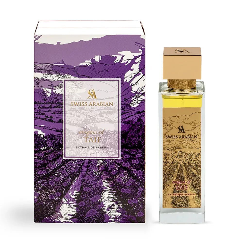 A rectangular bottle of Swiss Arabian Enigma of Taif 100ml Extrait de Parfum stands beside its purple, gold, and white box with mountain and flower designs. The label reads "Taif," highlighting this unisex Taif rose perfume by Swiss Arabian.