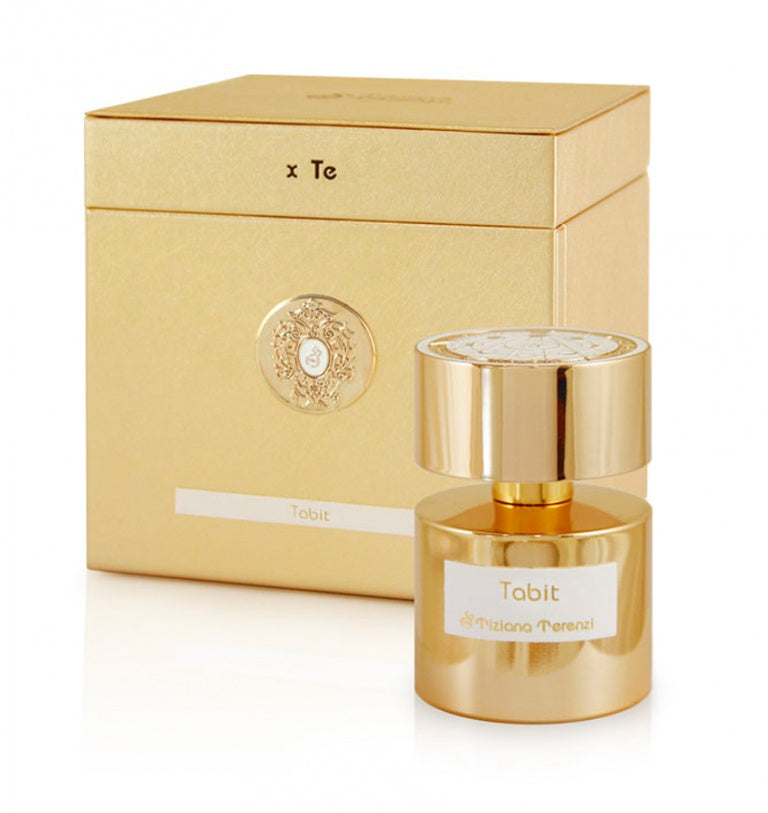 The Tiziana Terenzi Tabit 100ml Extrait De Parfum is shown in a gold bottle with white labels, displayed before its matching gold embossed box—an elegant unisex fragrance by Tiziana Terenzi.