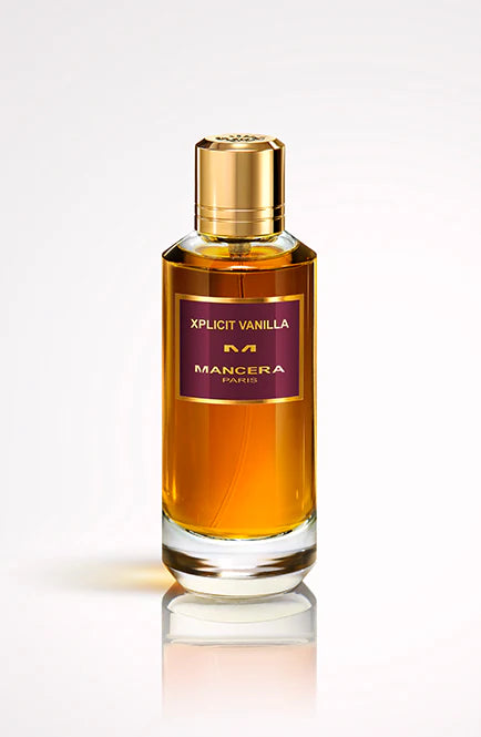 A 120ml glass bottle of Mancera Xplicit Vanilla Eau De Parfum, labeled "Xplicit Vanilla" with a gold cap and amber liquid, stands against a light background, reflecting the scent's rich vanilla essence.