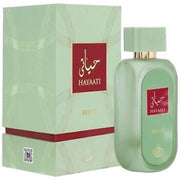 A green rectangular Fragrance World Hayaati Belle 100ml Eau De Parfum bottle with red and gold accents stands beside its matching box, offering a Floral Fruity scent for men and women.