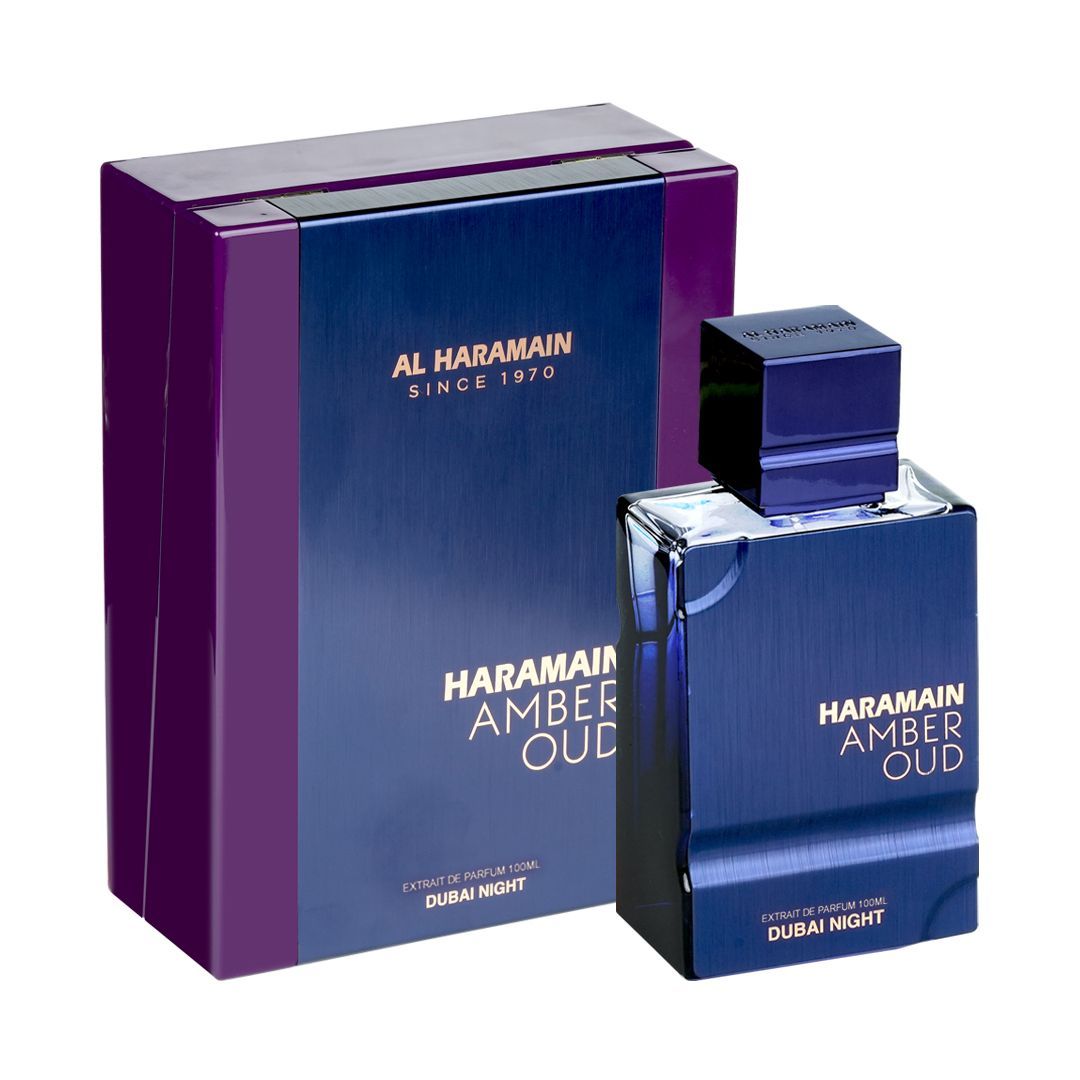 A luxurious fragrance for men and women, AL Haramain Amber Oud Dubai Night 100ml Extrait de Parfum comes in a blue-purple box and matching bottle with gold and white text on both the packaging and bottle.