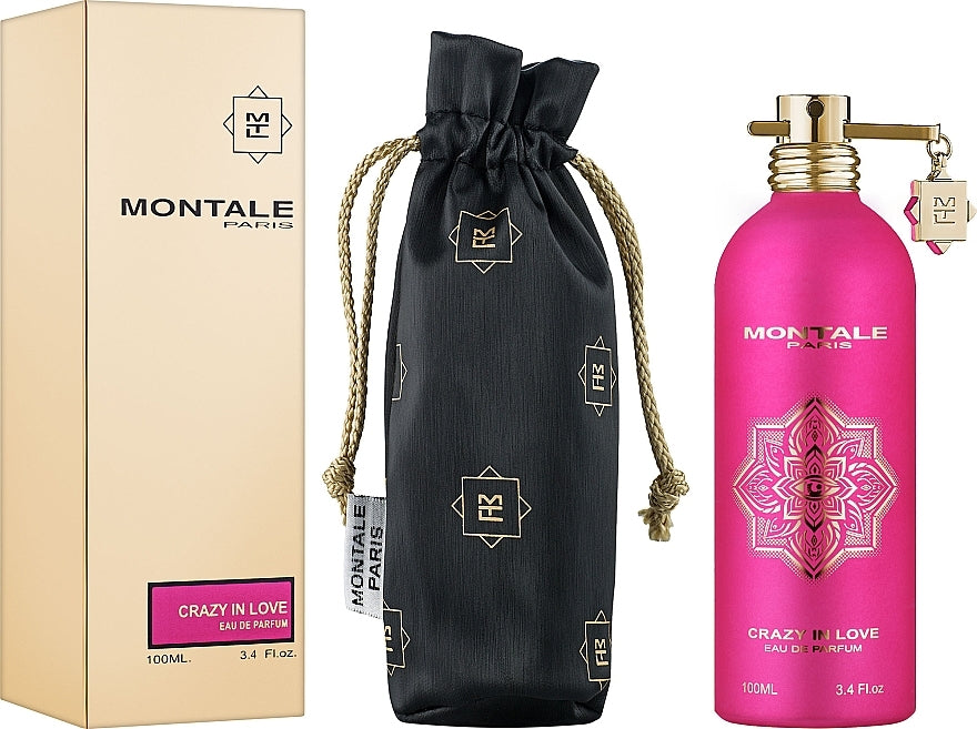 The Montale Paris Crazy In Love 50ml EDP set by Montale Paris includes a beige presentation box, a black logo pouch, and a vibrant pink bottle adorned with gold accents and keychain. This captivating unisex fragrance embodies elegance and passion in every detail.