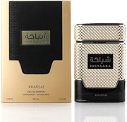 A 100ml bottle and box of Rio Perfumes Khadlaj Shiyaaka Gold EDP, both with a textured gold and black design displaying Arabic and English text.
