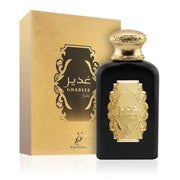 A black and gold bottle of Khadlaj Ghadeer Gold 100ml EDP stands before a matching decorative box, featuring Arabic script and patterns, representing this luxurious unisex perfume by Khadlaj.