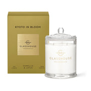 The Glasshouse Kyoto in Bloom 380g Soy Candle features camellia, lotus, and plum notes, displayed beside its gold and white packaging.