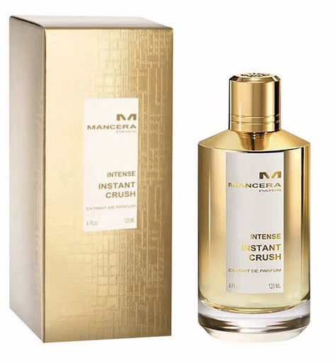 A gold and clear bottle of Mancera Intense Instant Crush 120ml EDP, a unisex fragrance by Mancera, is shown beside its matching gold box packaging.