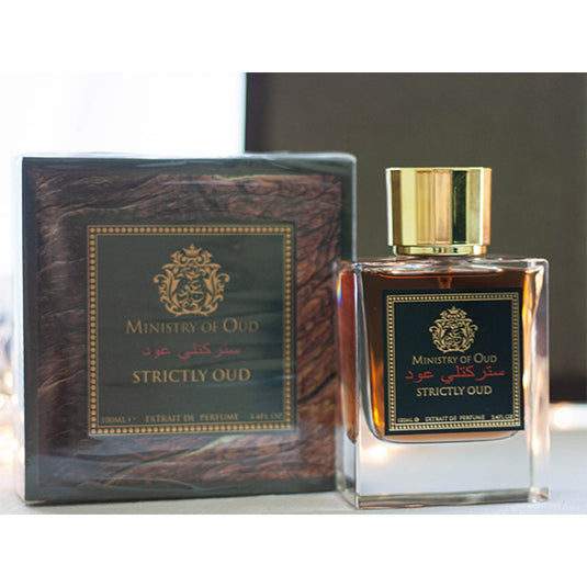 A bottle of Paris Corner Ministry of Oud Strictly Oud 100ml Extrait de Perfume from Dubai Perfumes sitting on a table next to a box.
